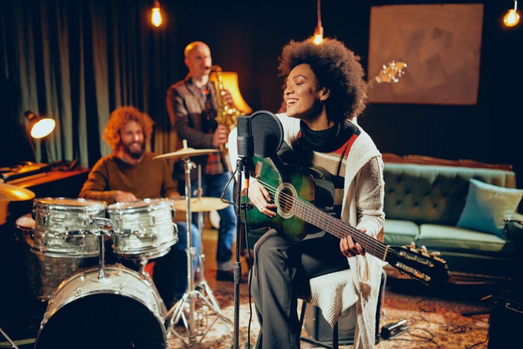 recording studio Girl with Afro Plays the acoustic guitar and sings