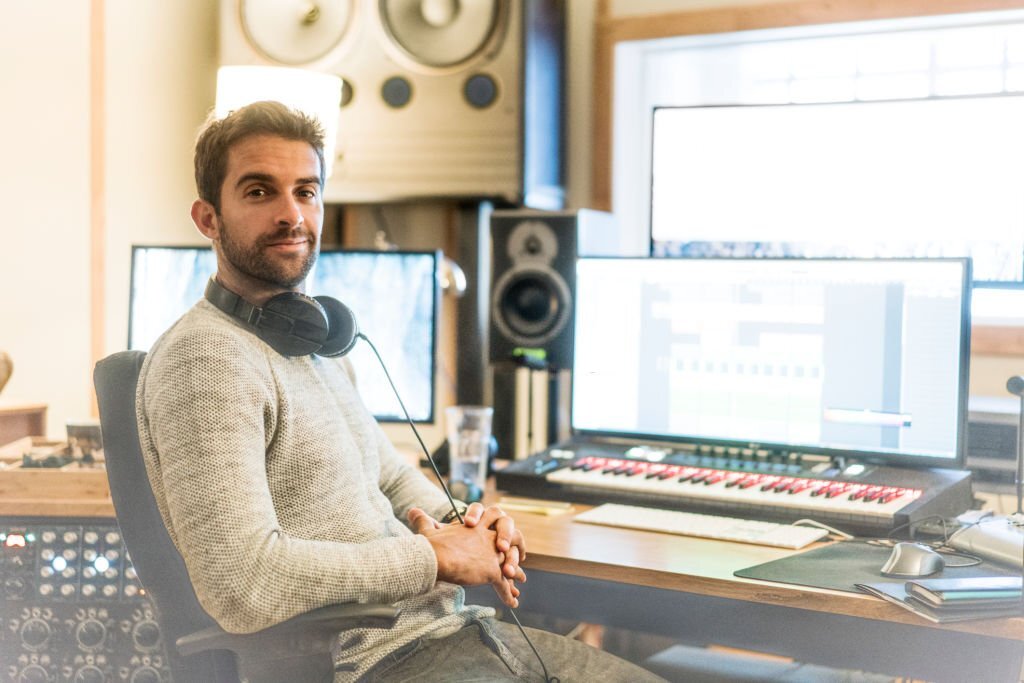 Portrait of confident sound engineer in recording studio.